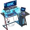 ODK Scrivania Gaming Angolare con Luci LED e Prese di Corrente, 100x70 cm Postazione Gaming con Supporto per Monitor & Ripiano di Stoccaggio Fibra di Carbonio Nera